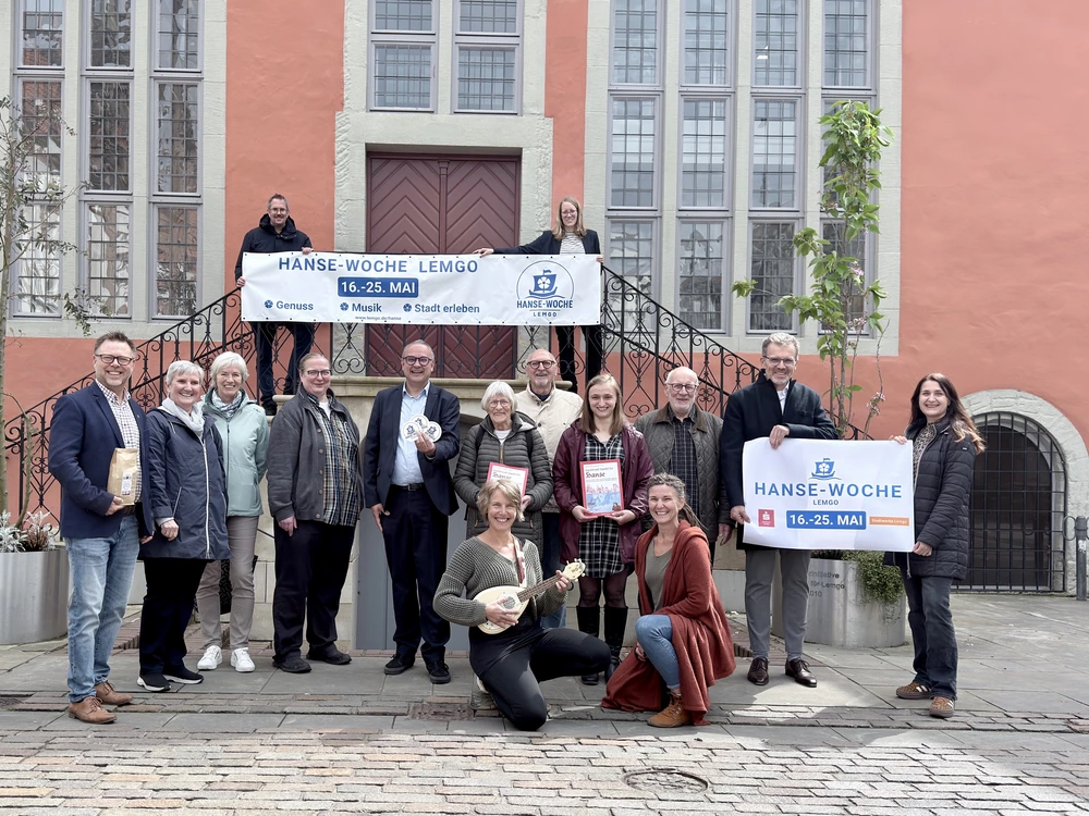Eine Gruppe von Menschen präsentiert ein Banner mit der Aufschrift "Hanse-Woche 16.-25. Mai 2026"