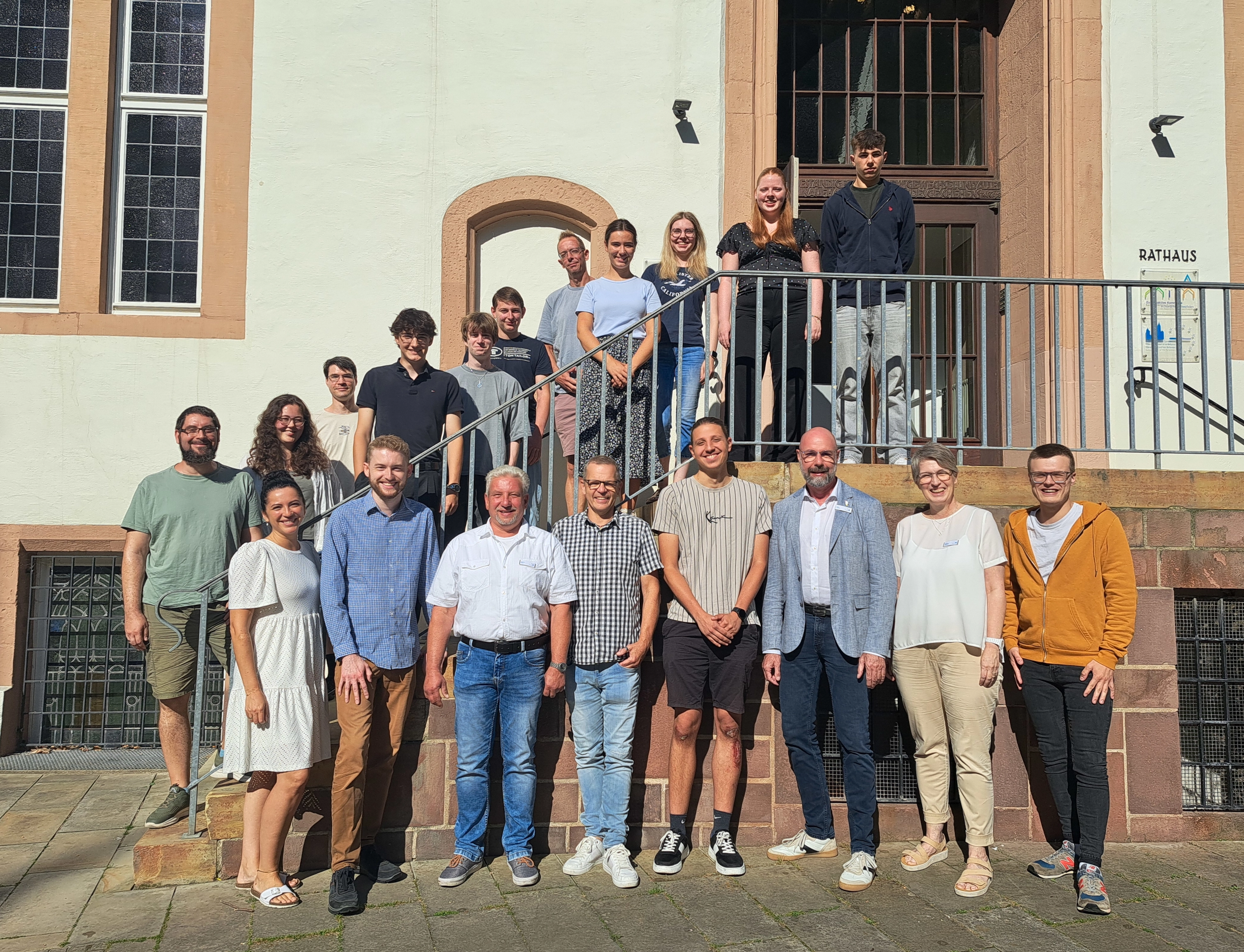 Diverse Leute stehen auf und vor einer Treppe