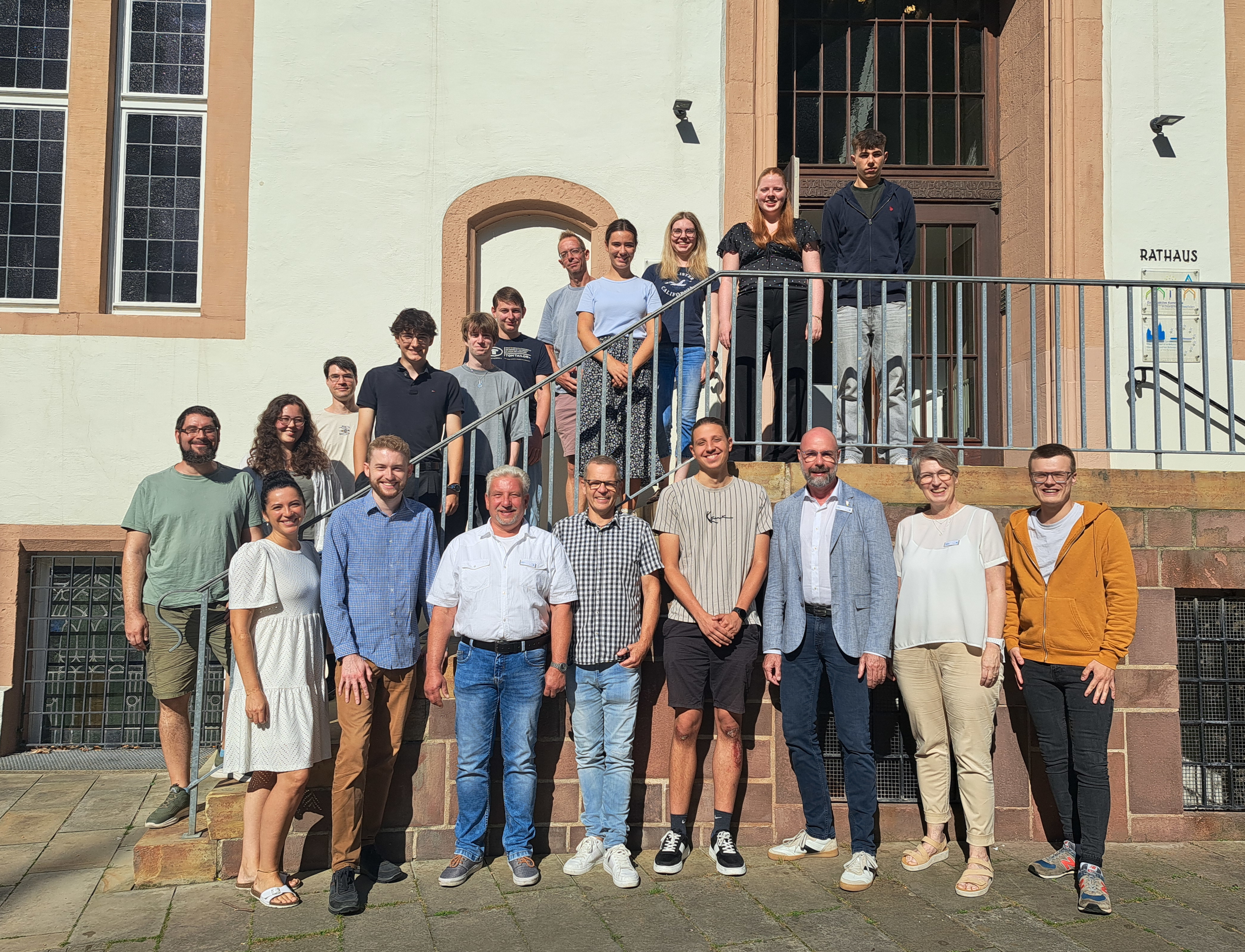 Diverse Leute stehen auf und vor einer Treppe