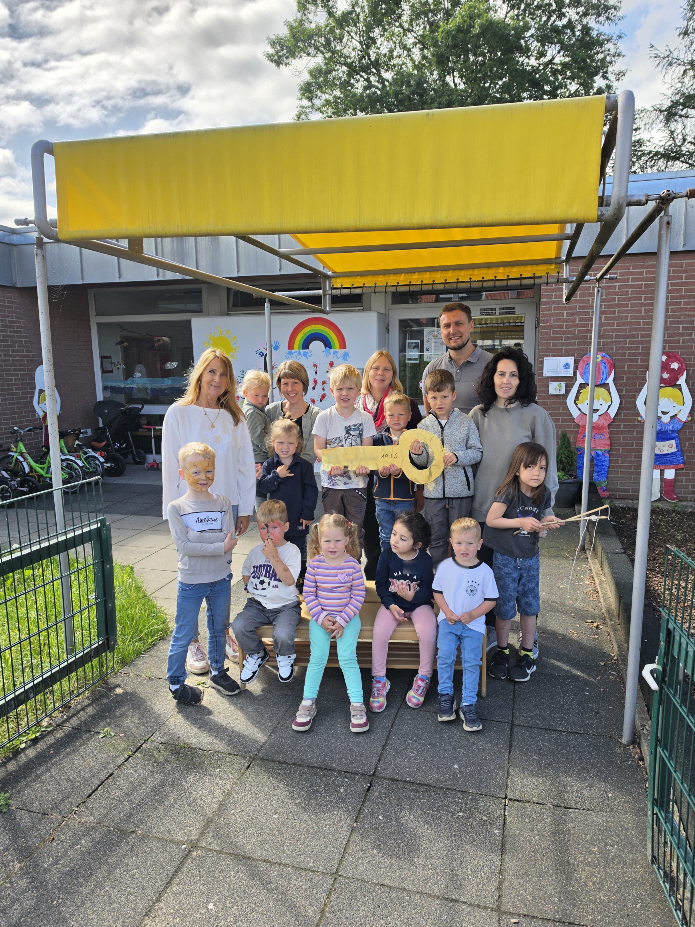 Eine Gruppe von Kindern und Erwachsenen steht vor dem Kindergarten Hörstmar.