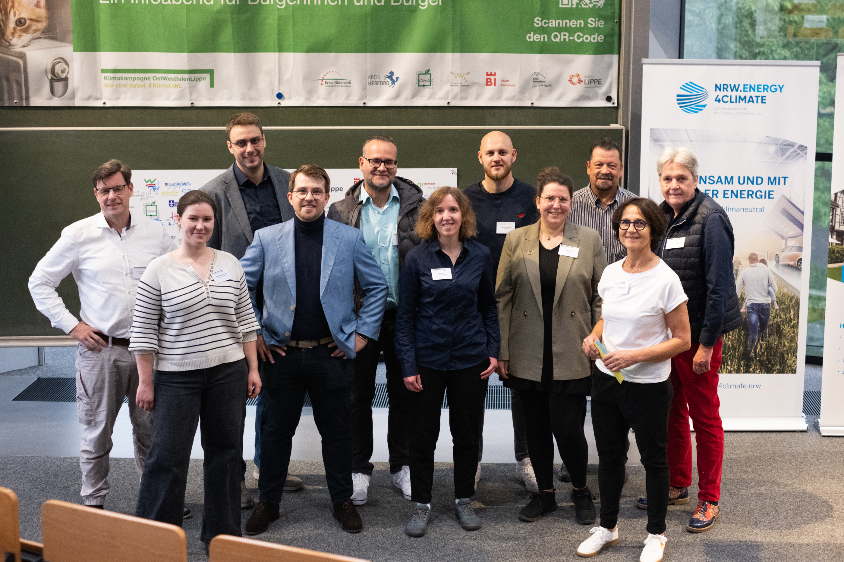Eine gruppe von Menschen steht vorne im Hörsaal.