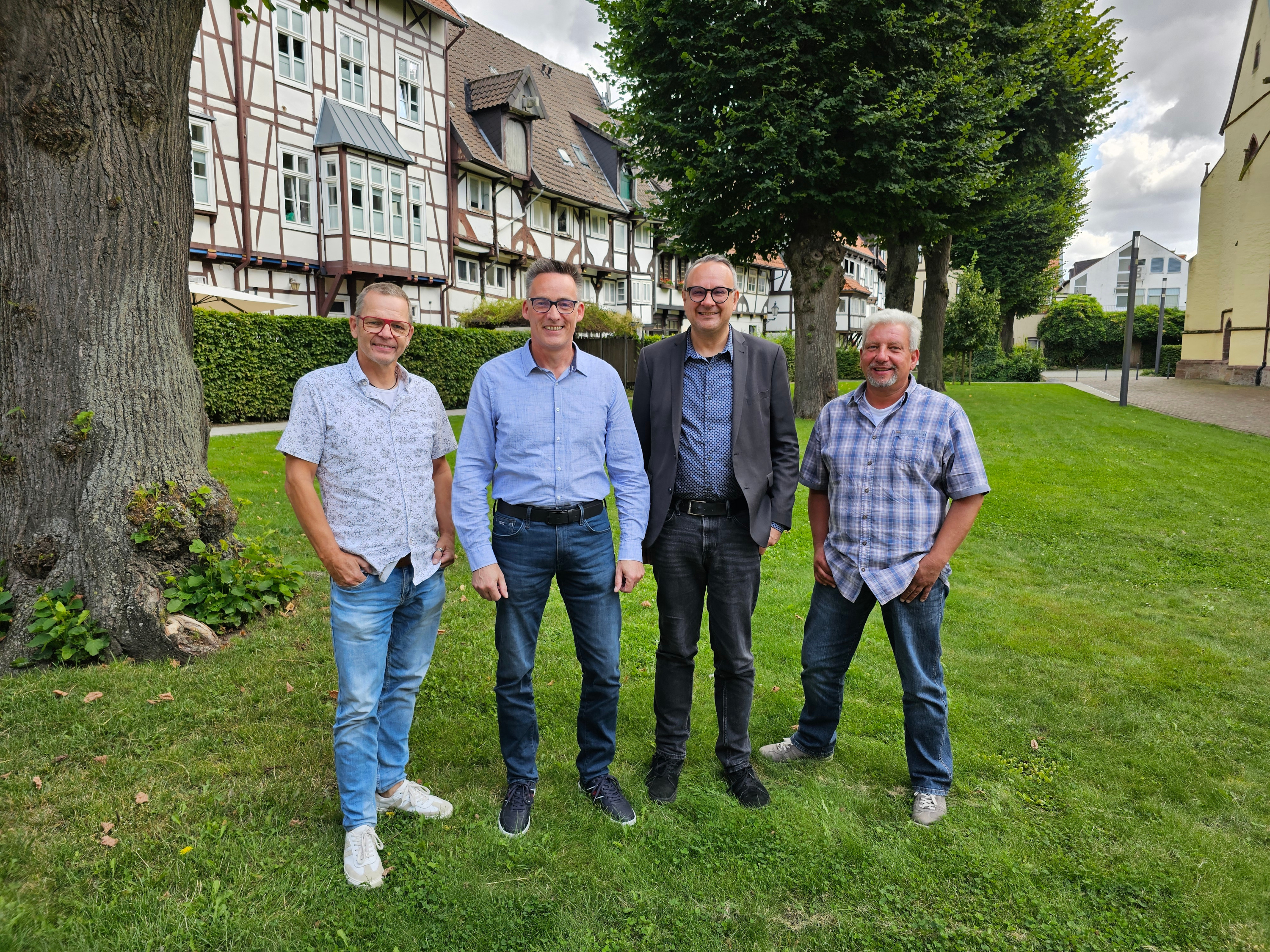 Vier Männer stehen nebeneinander im Freien.