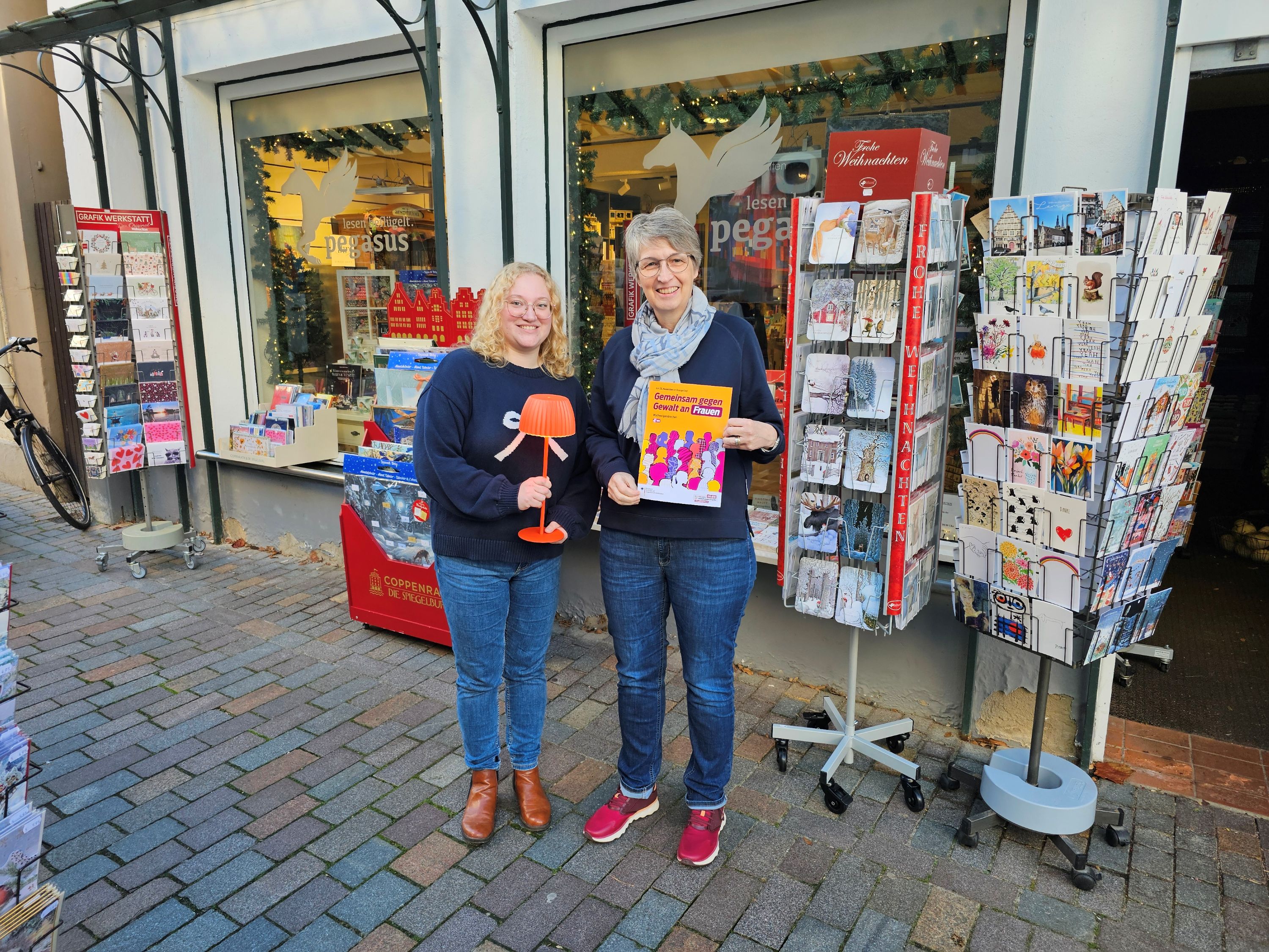 Übergabe der orangenen Leuchte vor der Buchhandlung Pegasus
