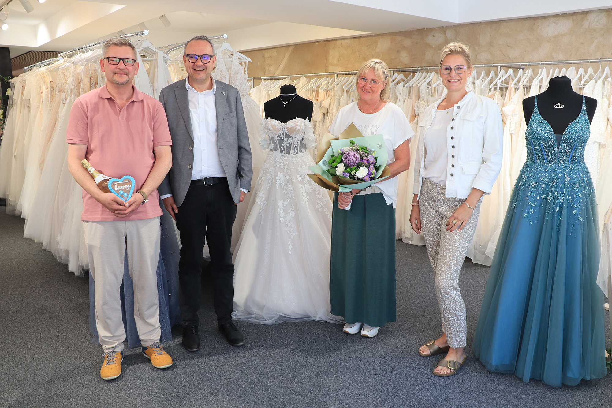 Arne Bednarzik („Trau(m)kleid“), Bürgermeister Markus Baier, Claudia Stenten („Trau(m)kleid“) und Rabea Kruel (Lemgo Marketing) stehen zwischen Braut- und Abendkleidern in dem neuen Geschäft.